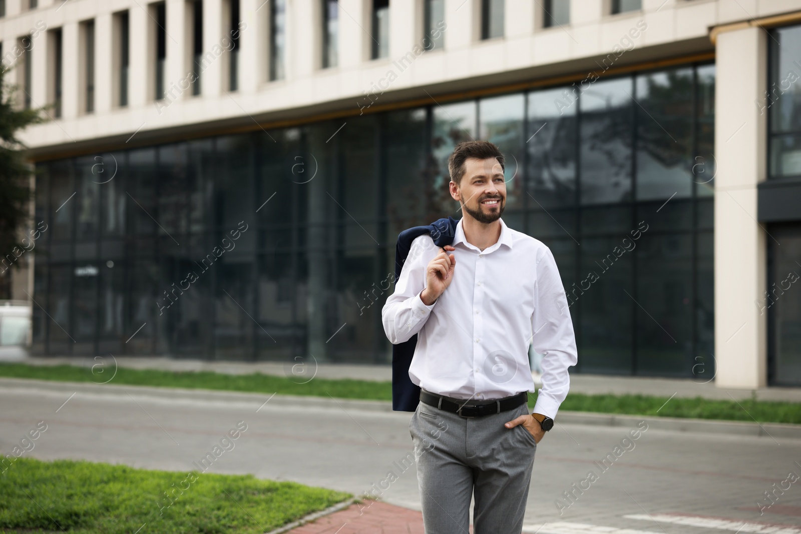 Photo of Handsome bearded businessman walking on city street