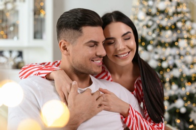 Photo of Happy couple in festively decorated room. Christmas celebration