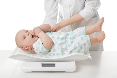 Photo of Doctor weighting baby on scales against white background