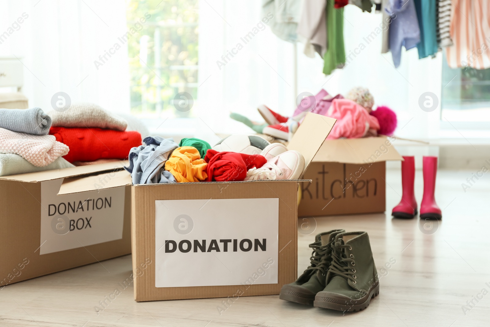 Photo of Donation boxes with clothes on floor indoors