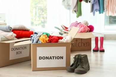 Donation boxes with clothes on floor indoors