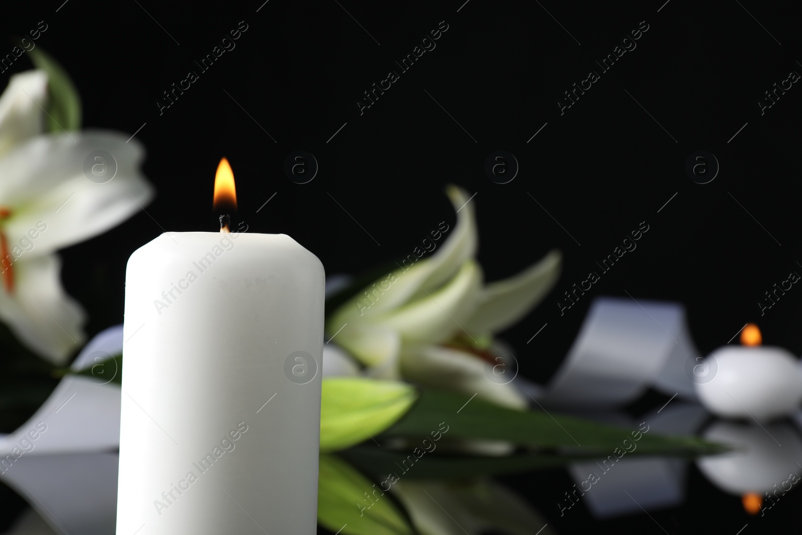 Photo of Burning candle in darkness, closeup with space for text. Funeral symbol