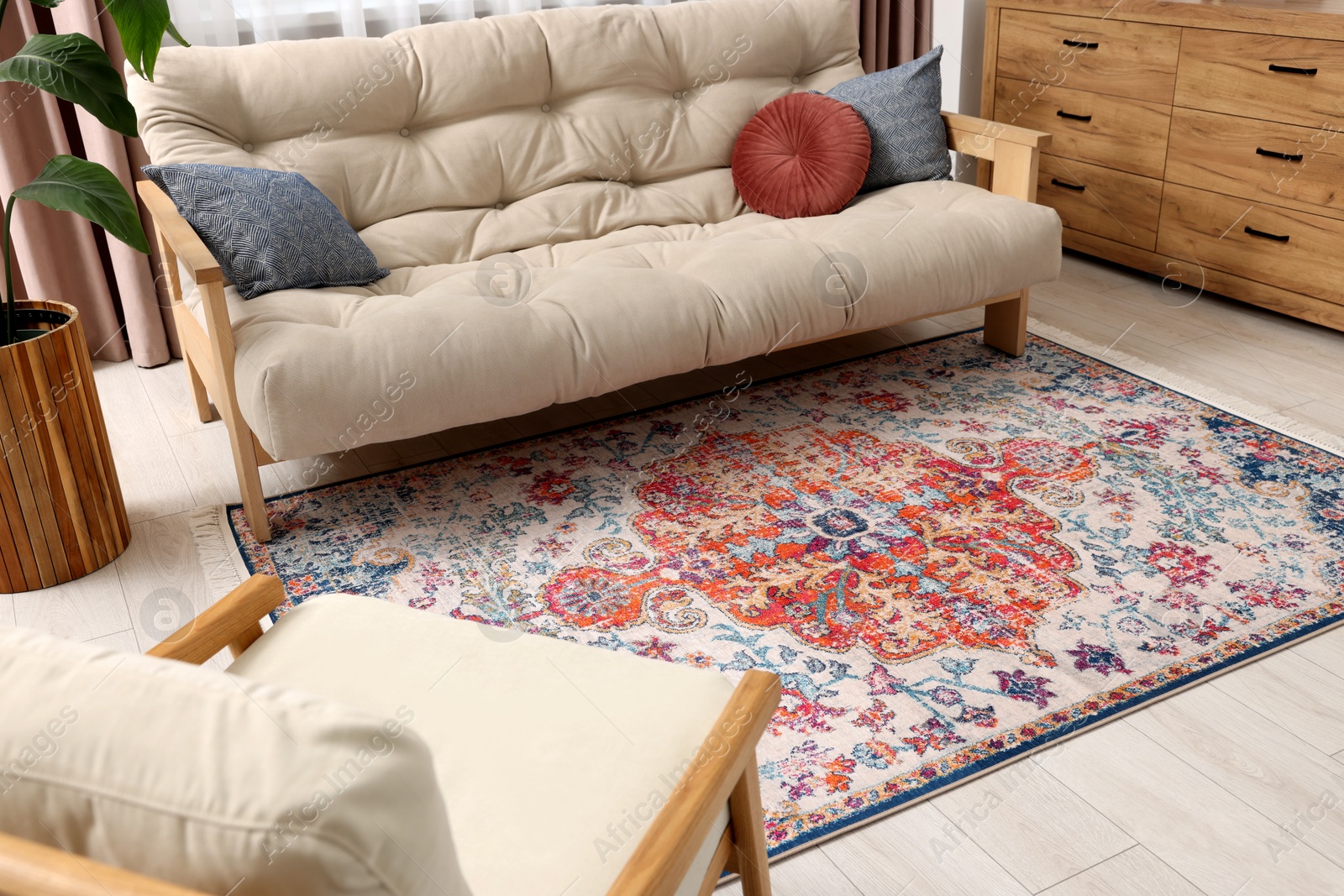 Photo of Beautiful rug, sofa and chest of drawers indoors