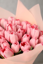 Photo of Bouquet of beautiful pink tulips on light grey background, closeup