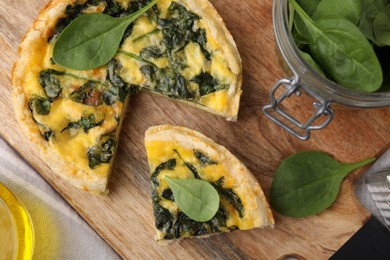 Photo of Delicious cut pie with spinach on table, flat lay