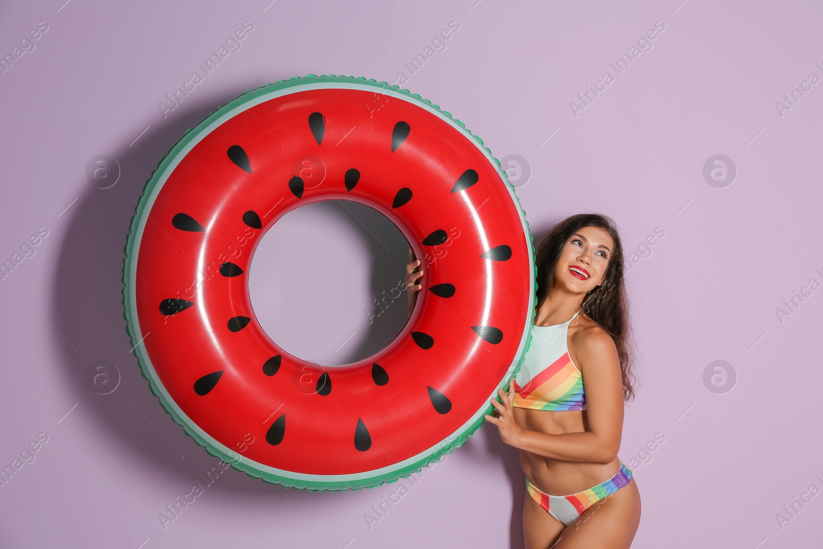 Photo of Beautiful young woman with inflatable ring on color background