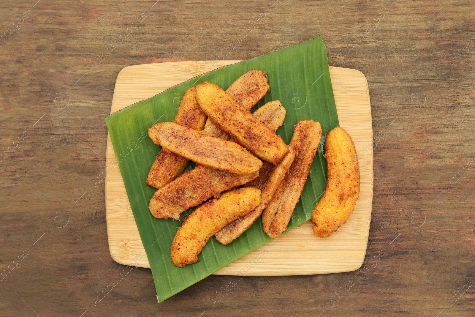 Photo of Delicious fried bananas on wooden table, top view