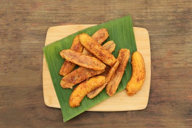 Photo of Delicious fried bananas on wooden table, top view