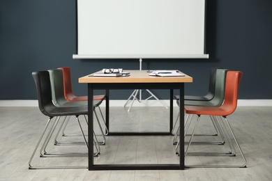 Photo of Modern meeting room interior with large table and projection screen