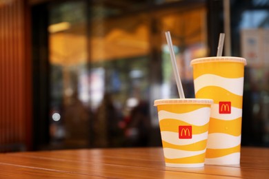 Photo of MYKOLAIV, UKRAINE - AUGUST 11, 2021: Cold McDonald's drinks on table in cafe. Space for text