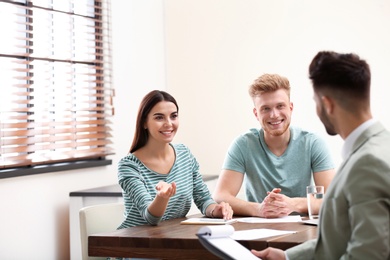 Insurance agent consulting young couple in office