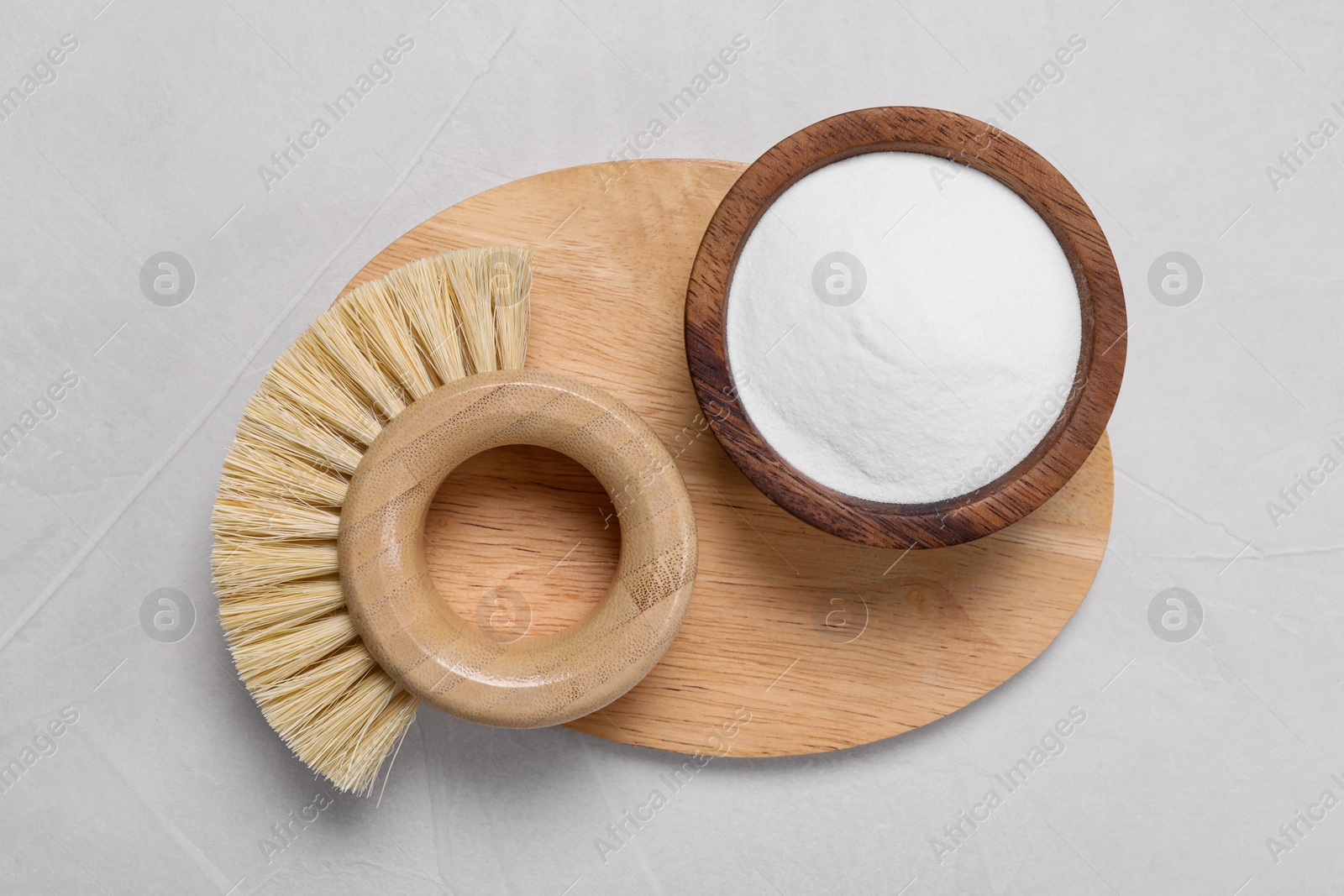 Photo of Cleaning brushes and baking soda on white table, top view