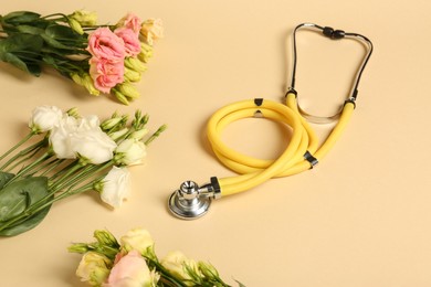 Stethoscope and eustoma flowers on beige background. Happy Doctor's Day