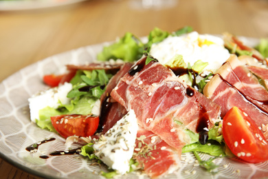 Photo of Delicious prosciutto salad with vegetables on plate, closeup