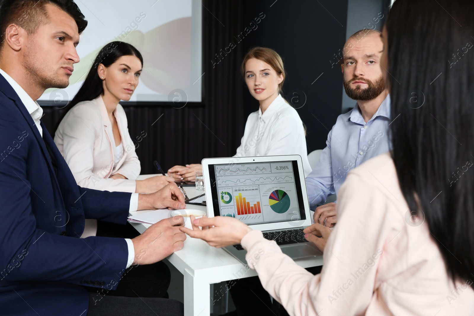 Photo of Business people having meeting in conference room with video projection screen