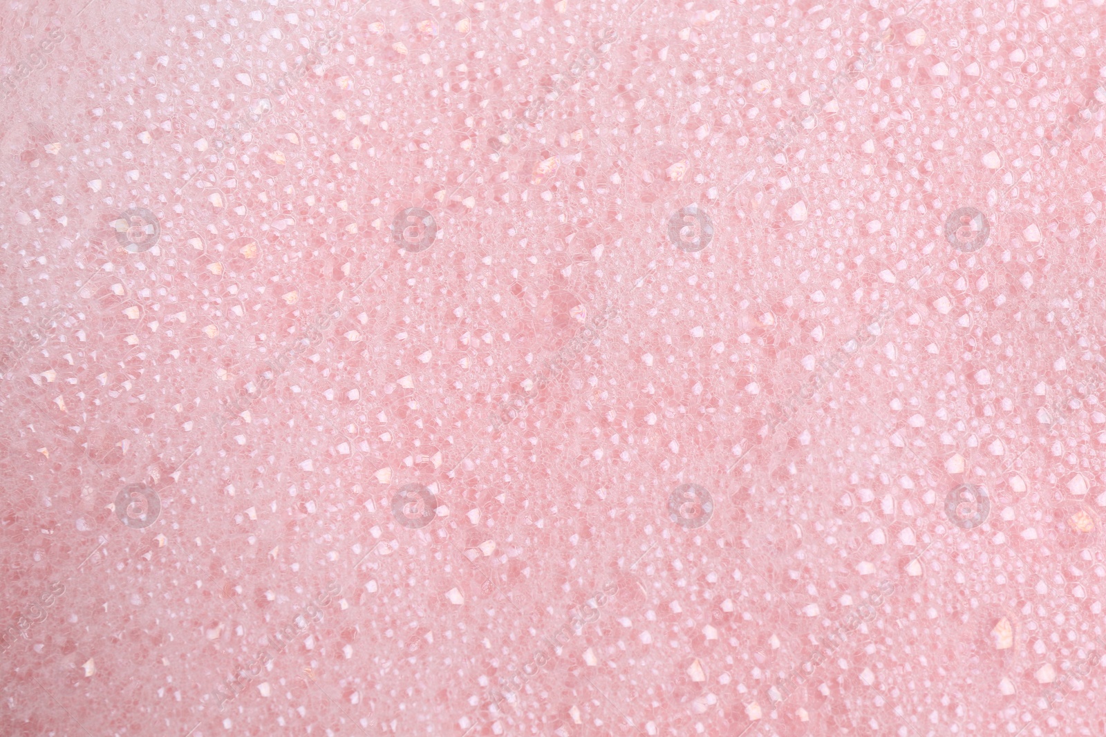 Photo of White fluffy foam on pink background, top view