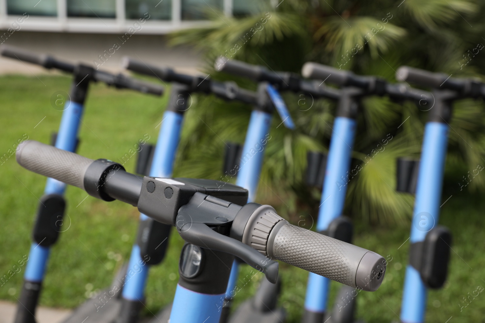 Photo of Modern electric scooters outdoors, closeup. Rental service