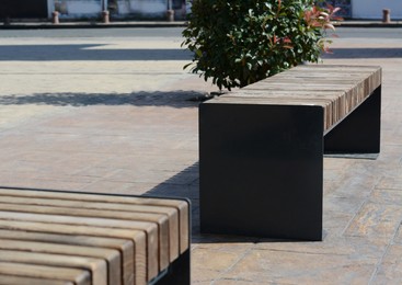 Photo of Wooden benches in city street on sunny day