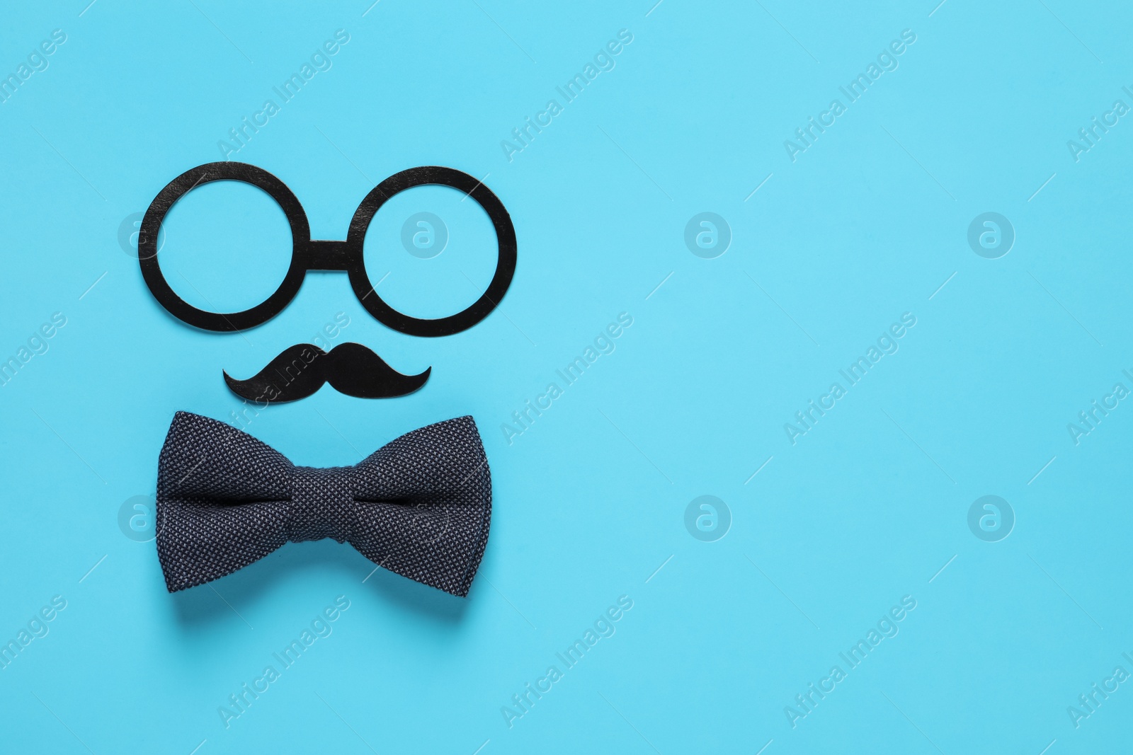 Photo of Paper glasses, mustache and bow tie on light blue background, flat lay with space for text. Father's day celebration