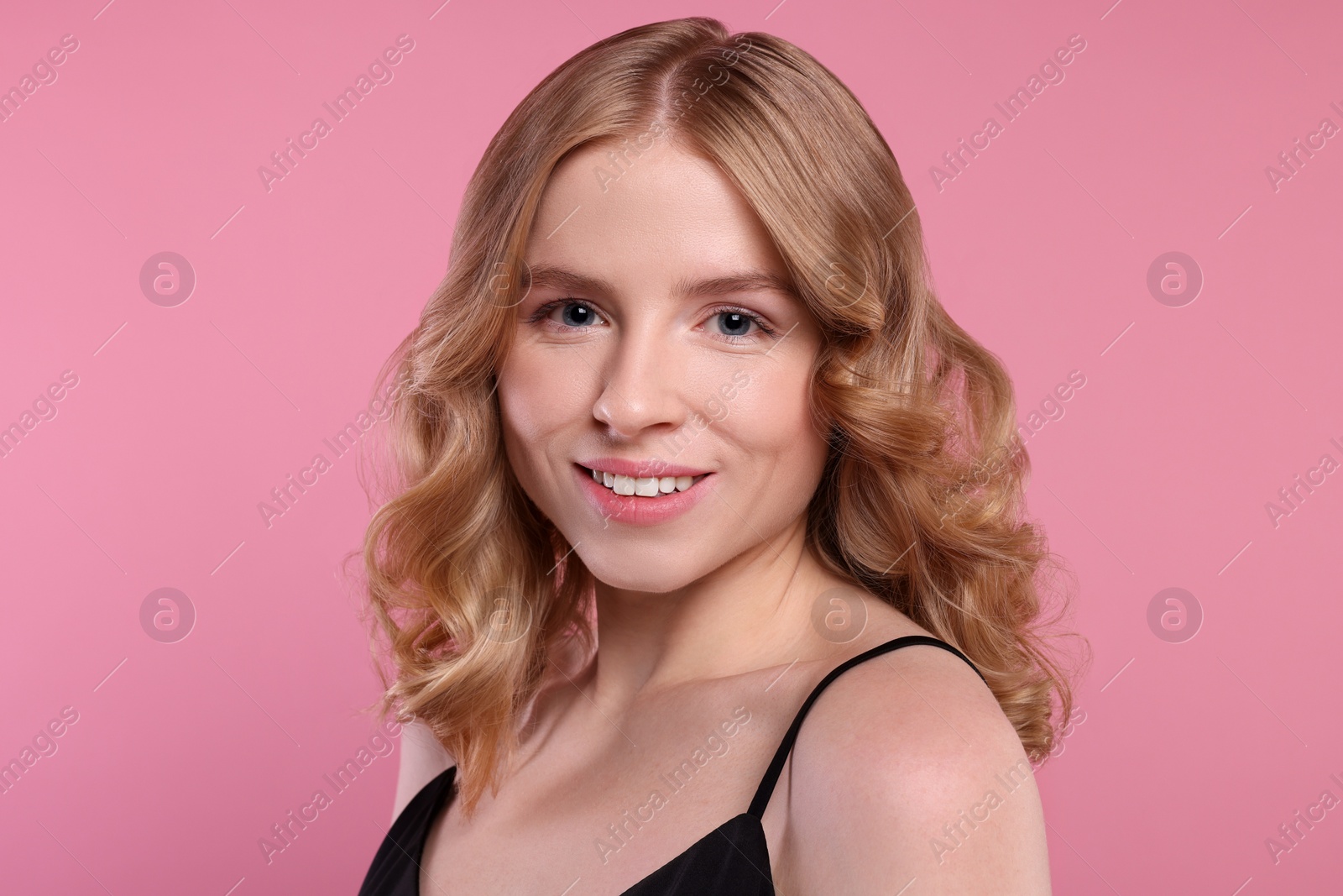 Photo of Portrait of beautiful woman with blonde hair on pink background