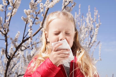 Photo of Little girl suffering from seasonal allergy outdoors