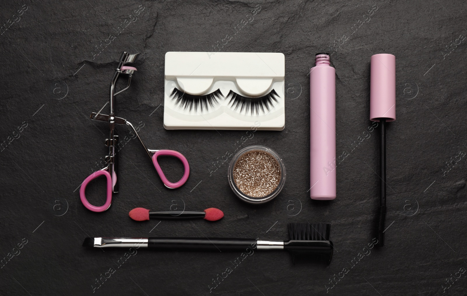 Photo of Flat lay composition with eyelash curler, makeup products and accessories on black table