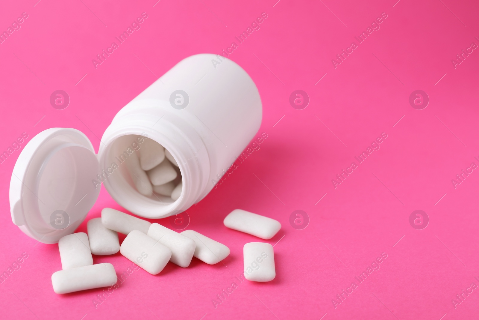 Photo of Jar with chewing gums on pink background. Space for text