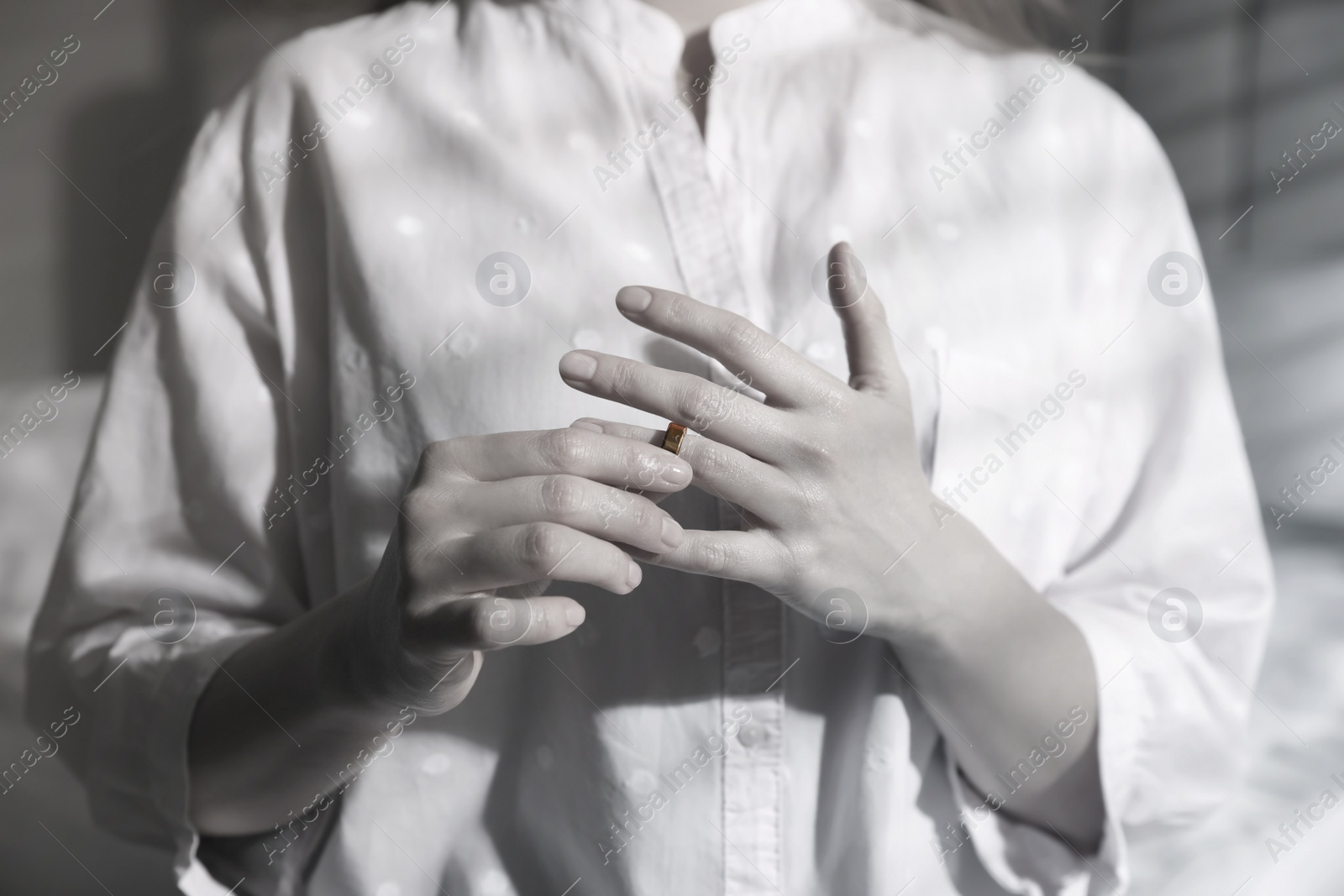 Image of Woman taking off wedding ring indoors, closeup. Cheating and breakup