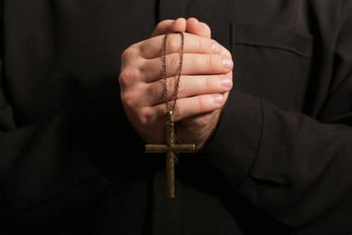 Priest in cassock with cross, closeup view