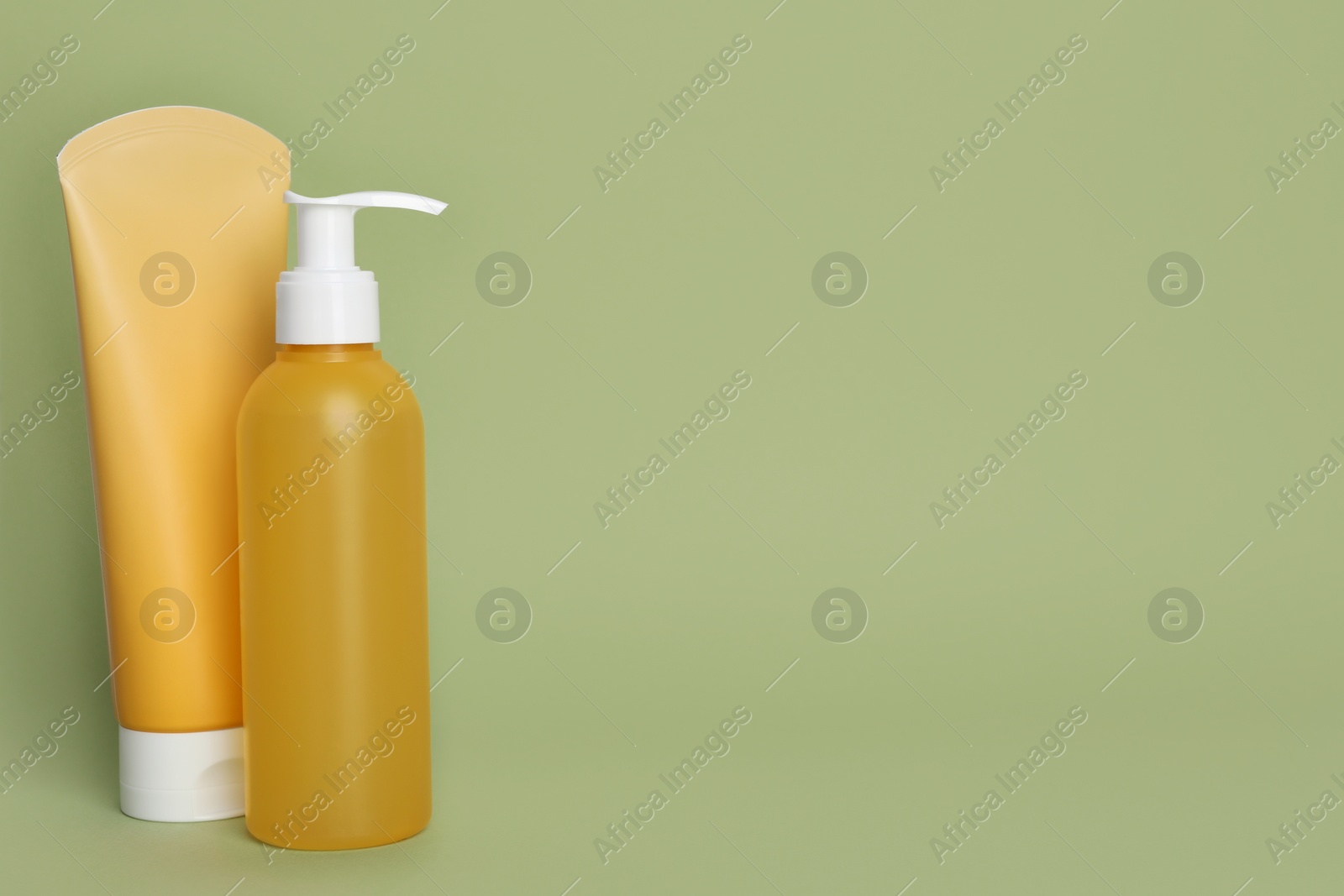 Photo of Different cleansers on olive background, space for text. Cosmetic product