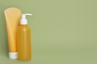 Photo of Different cleansers on olive background, space for text. Cosmetic product