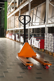 Photo of Modern manual pallet truck in wholesale warehouse