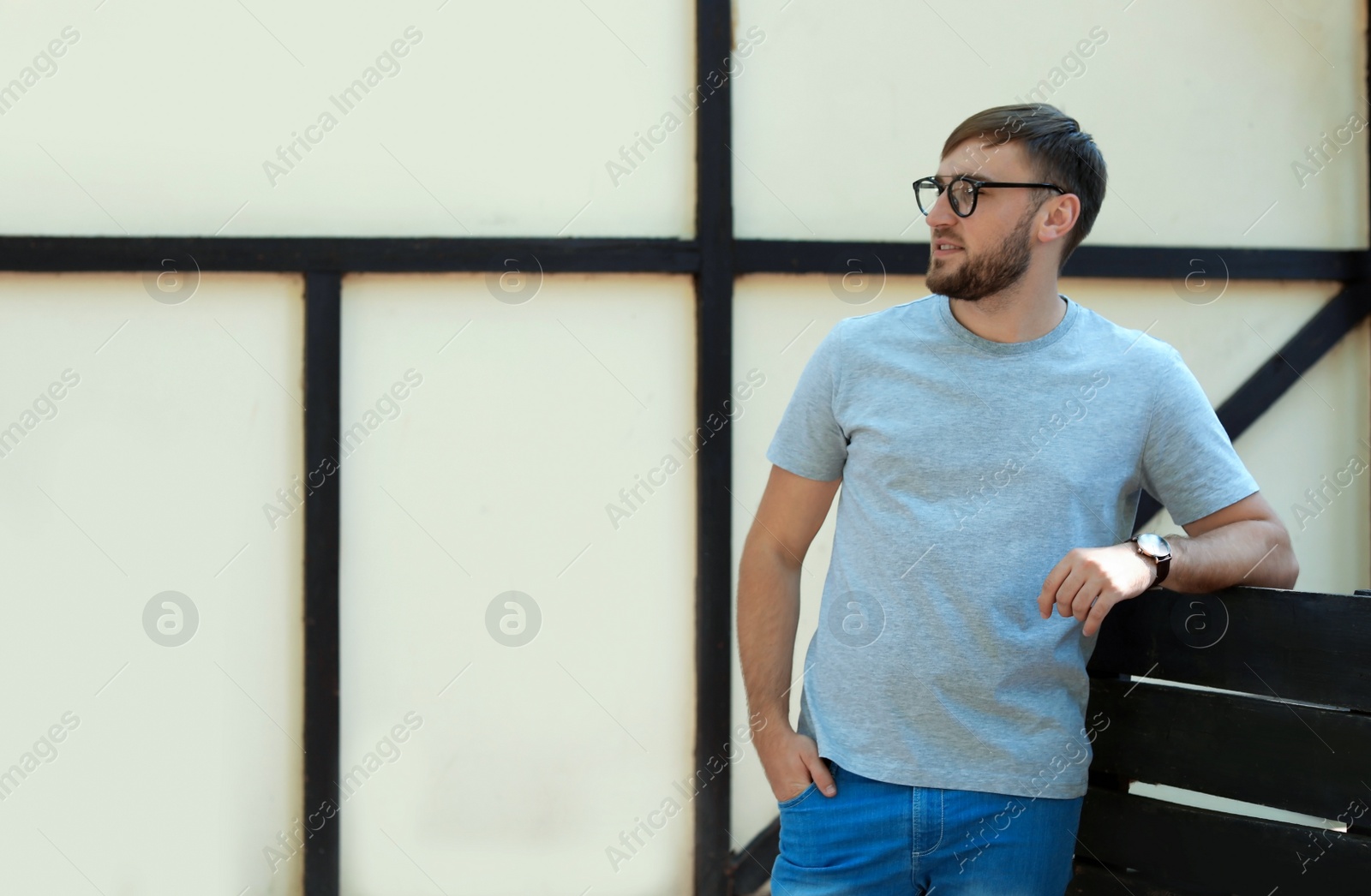 Photo of Young man wearing gray t-shirt on street. Urban style