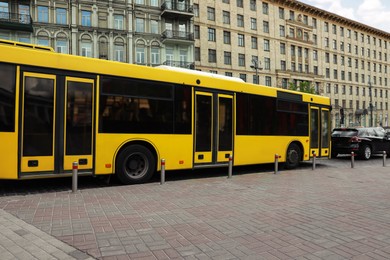 Photo of Modern yellow bus with passengers on city street