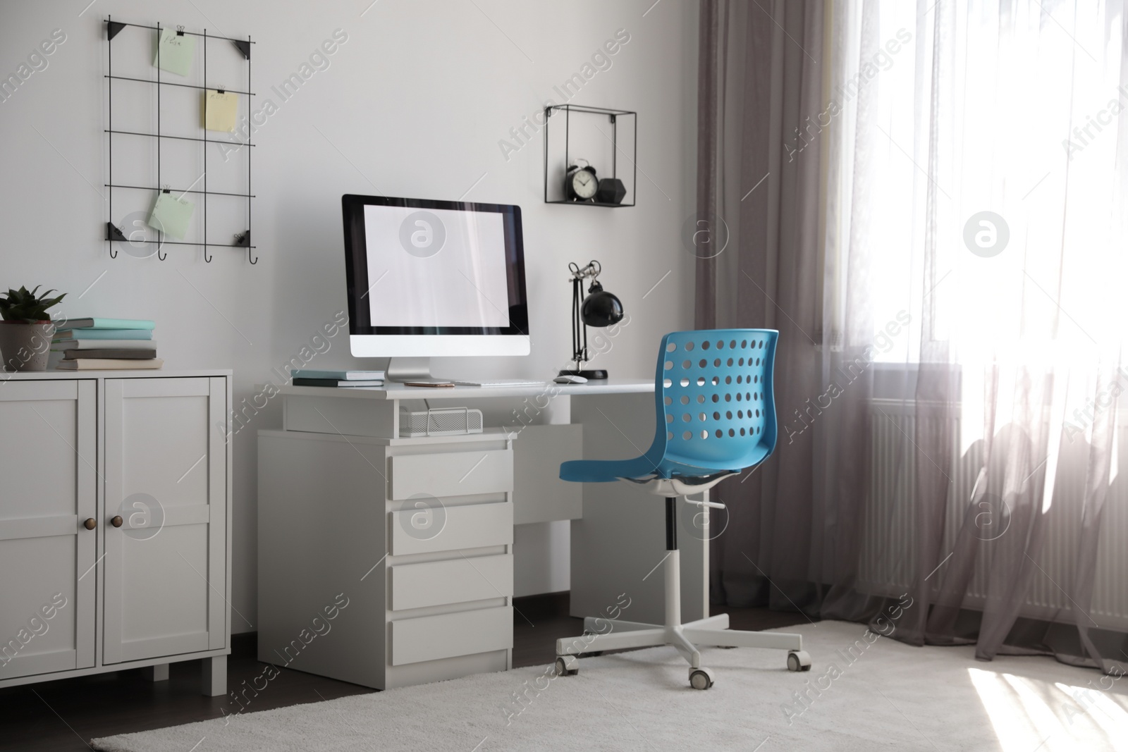 Photo of Comfortable blue chair near desk in stylish office interior