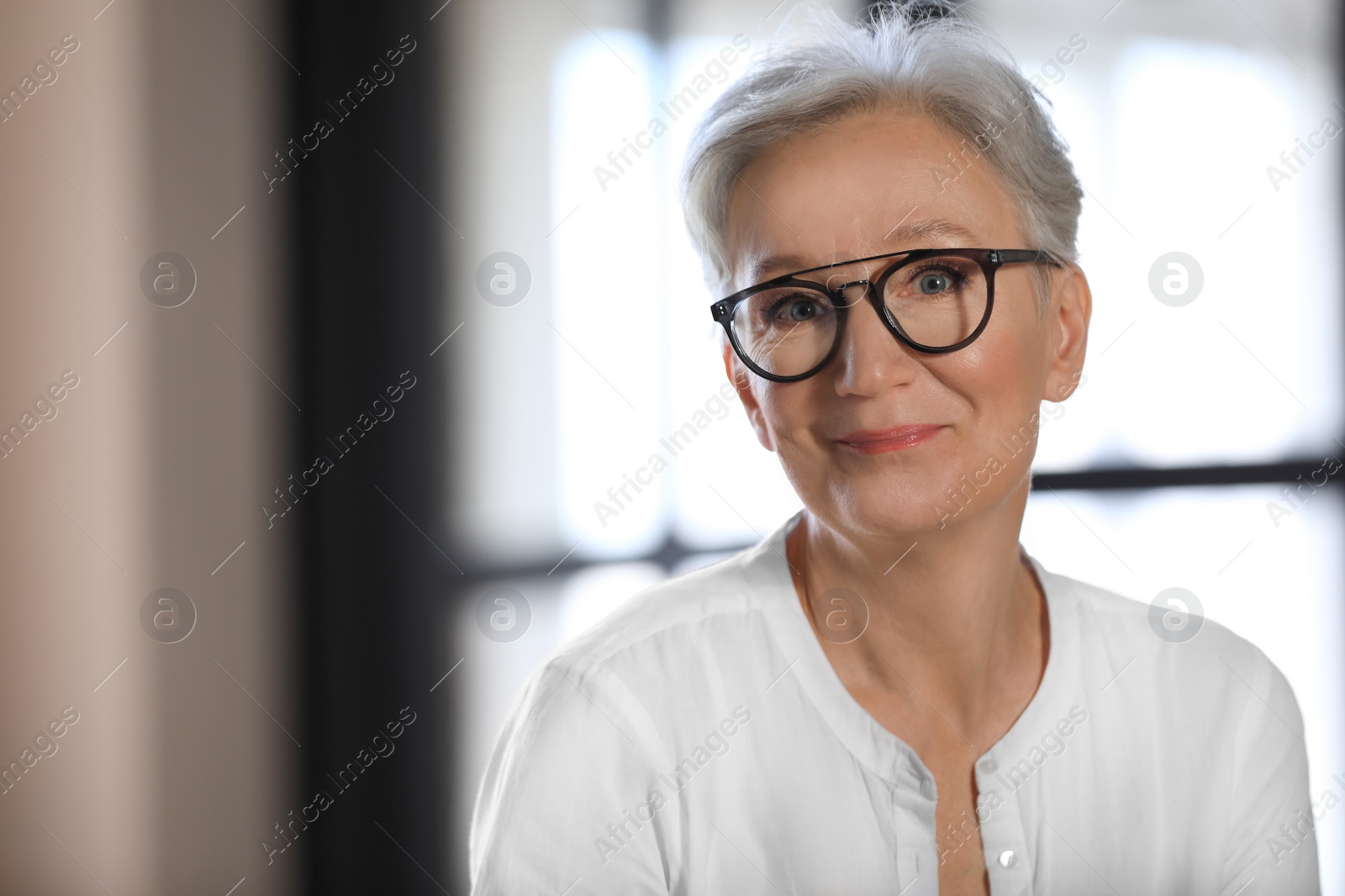 Photo of Happy mature woman in glasses indoors, space for text. Smart aging