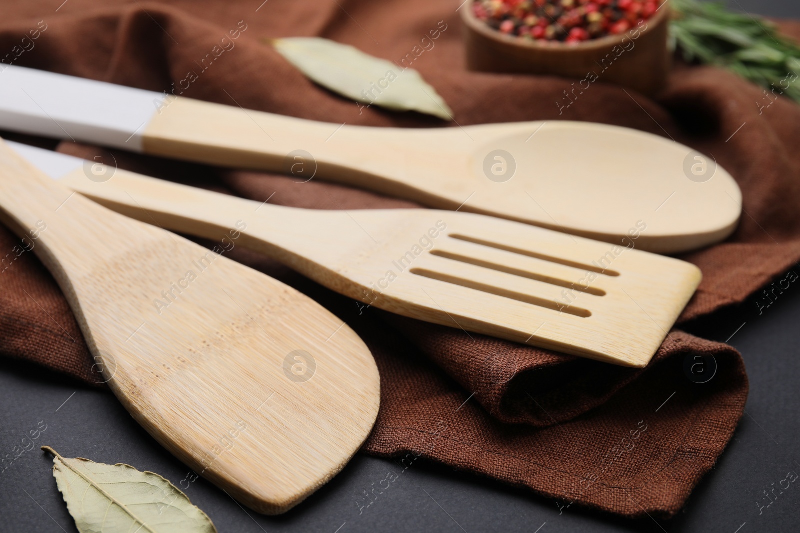 Photo of Set of wooden kitchen utensils on black table, closeup