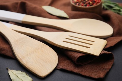 Photo of Set of wooden kitchen utensils on black table, closeup