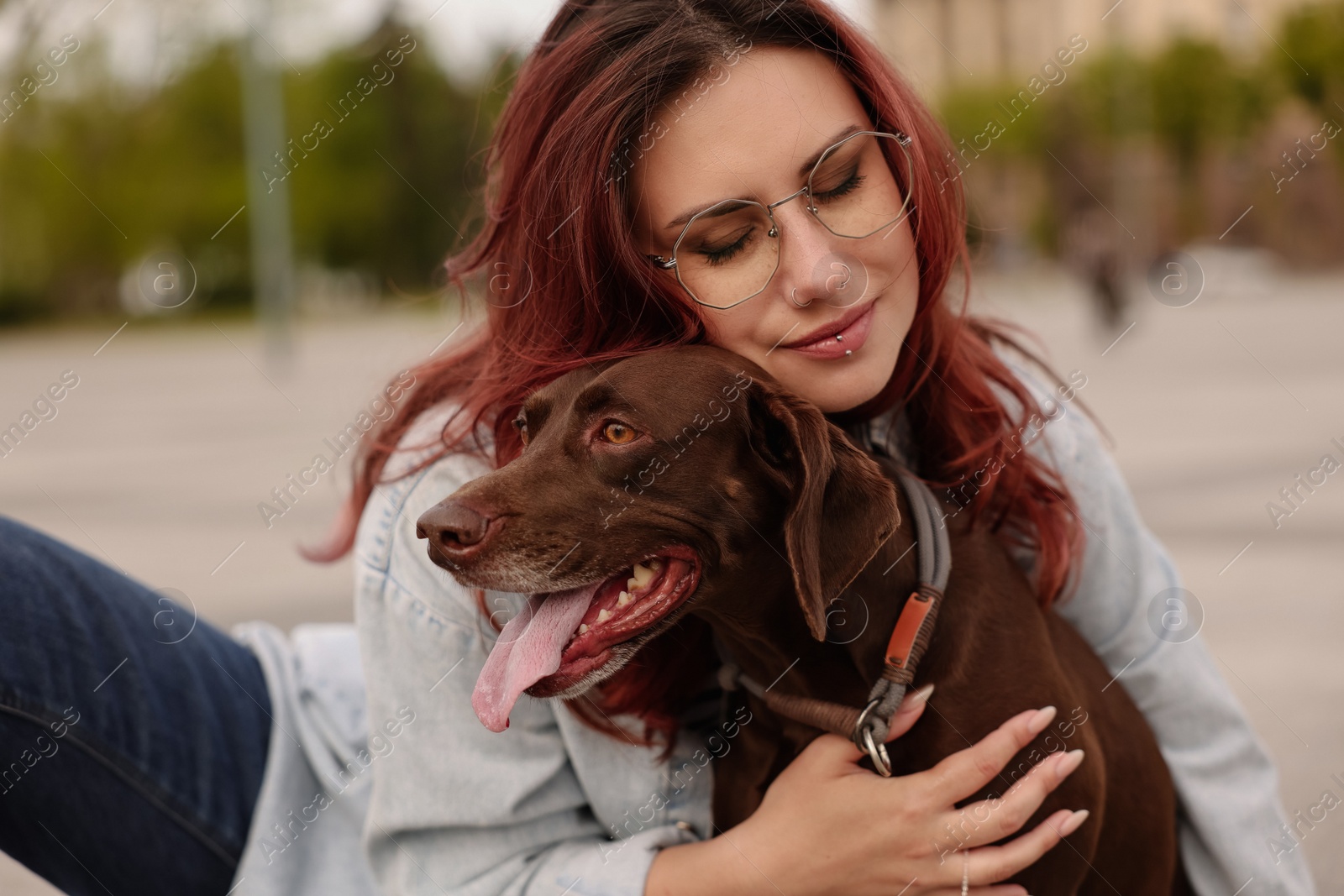 Photo of Woman with her cute German Shorthaired Pointer dog outdoors