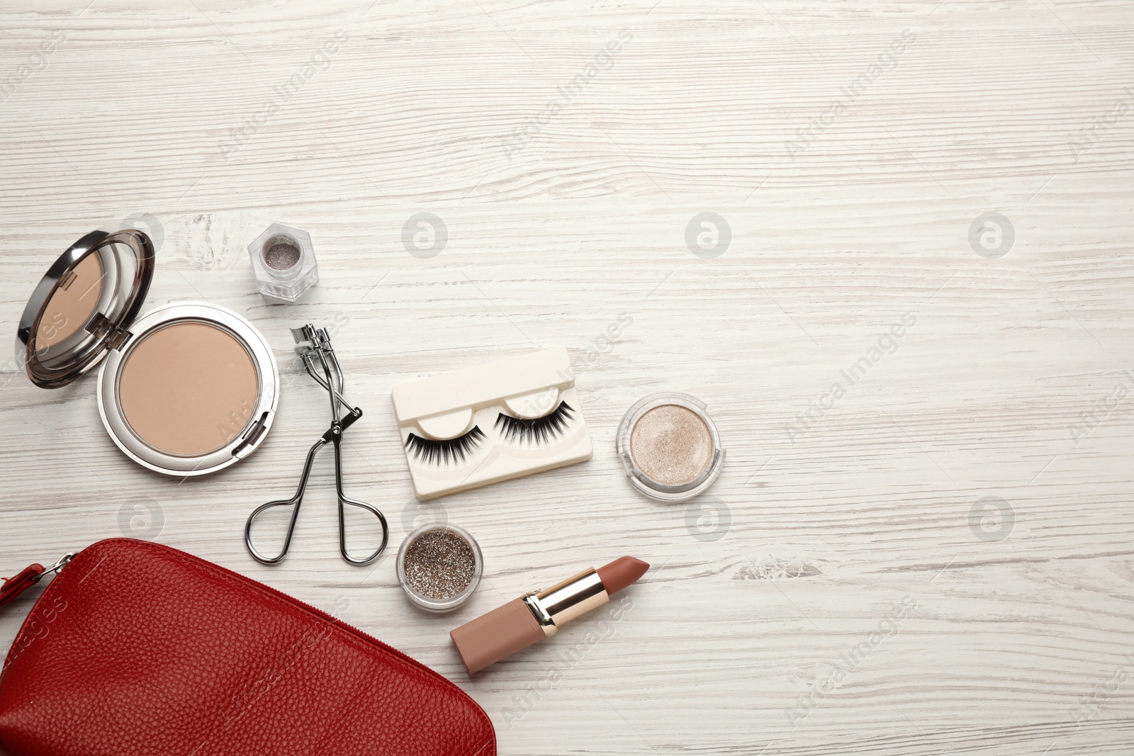 Photo of Flat lay composition with eyelash curler, makeup products and accessories on white wooden table. Space for text