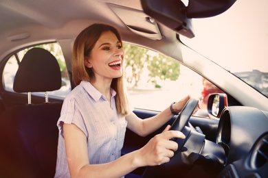 Happy beautiful woman driving modern car