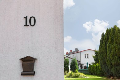 Photo of House number 10 on light textured wall outdoors