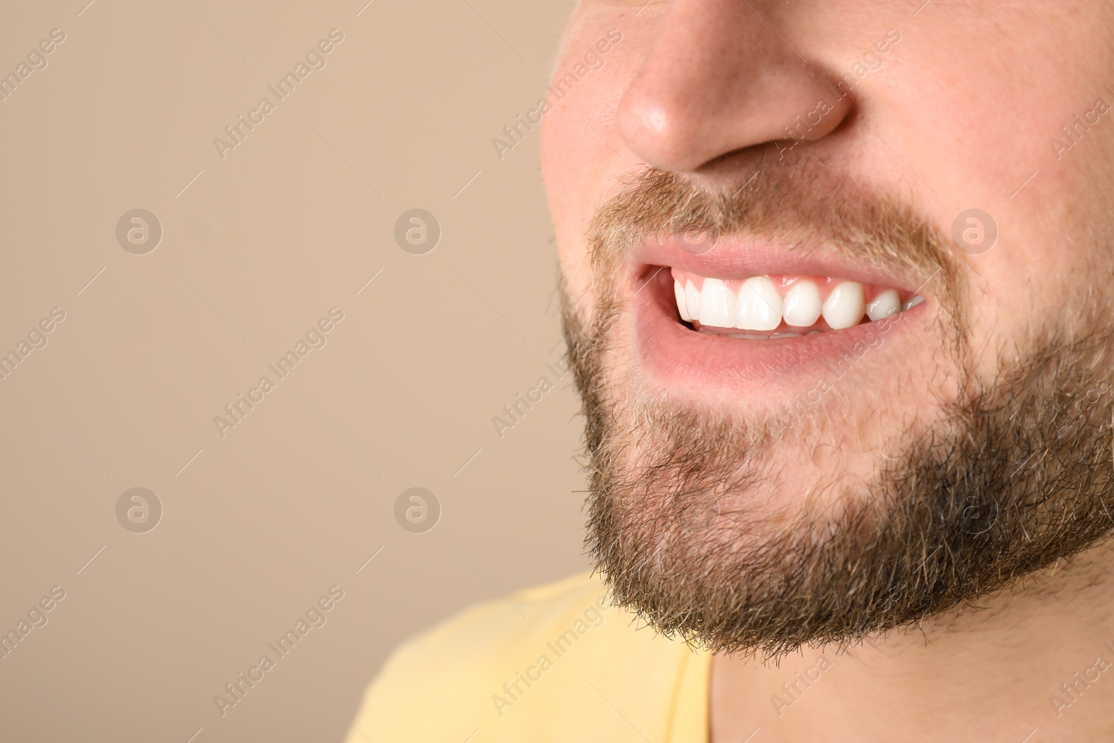 Photo of Young man with healthy teeth on color background, closeup. Space for text