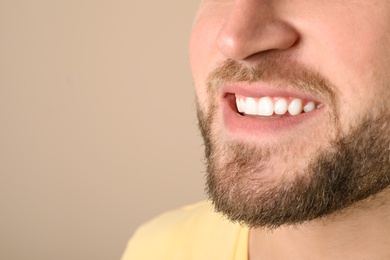 Photo of Young man with healthy teeth on color background, closeup. Space for text