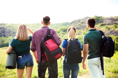 Photo of Group of young people with backpacks in wilderness. Camping season