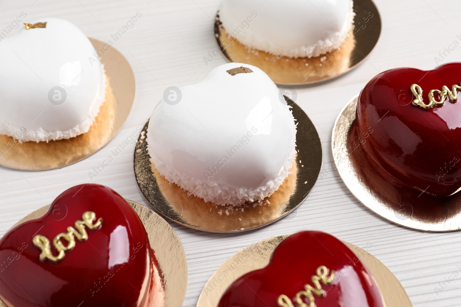 Photo of St. Valentine's Day. Delicious heart shaped cakes on white wooden table, closeup