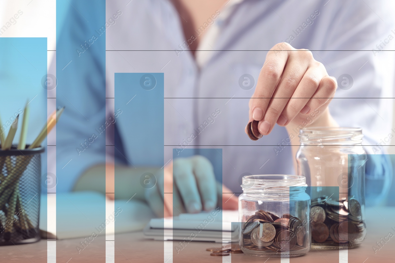 Image of Finance trading concept. Woman putting coins into jar at table and diagram, closeup