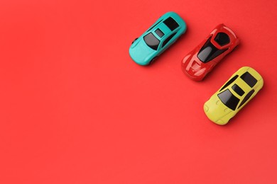 Different bright cars on red background, flat lay. Space for text