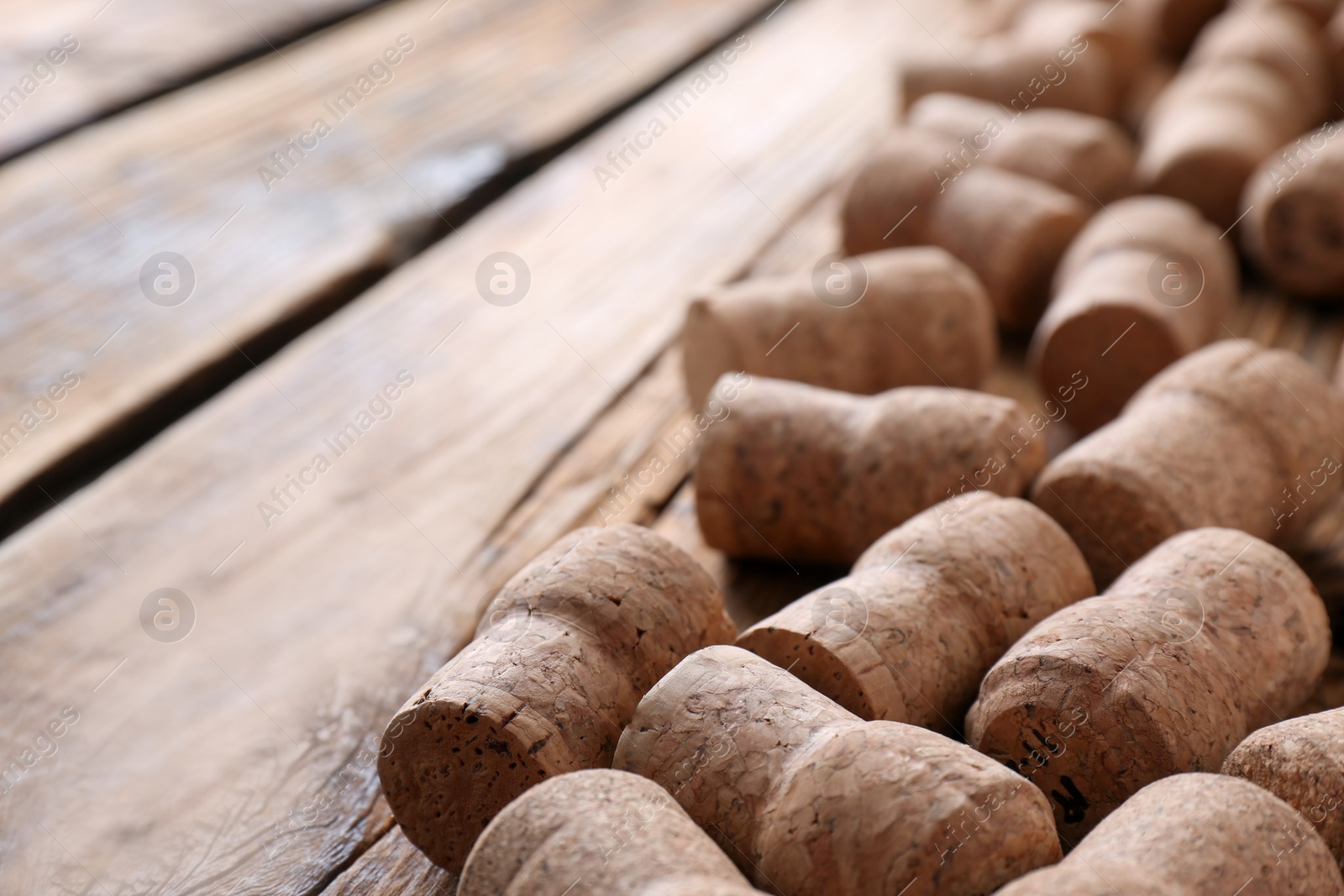 Photo of Sparkling wine bottle corks on wooden table, closeup. Space for text