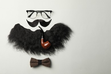 Photo of Flat lay composition with artificial moustache and glasses on light grey background, space for text